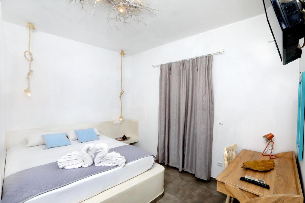 a bedroom with a bed and a desk and a television at Pension Verykokkos in Naxos Chora