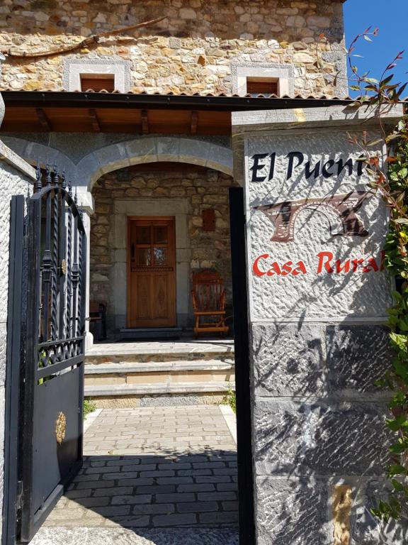 an entrance to a building with a gate and a sign at Casa Rural El Puente in Polvoredo