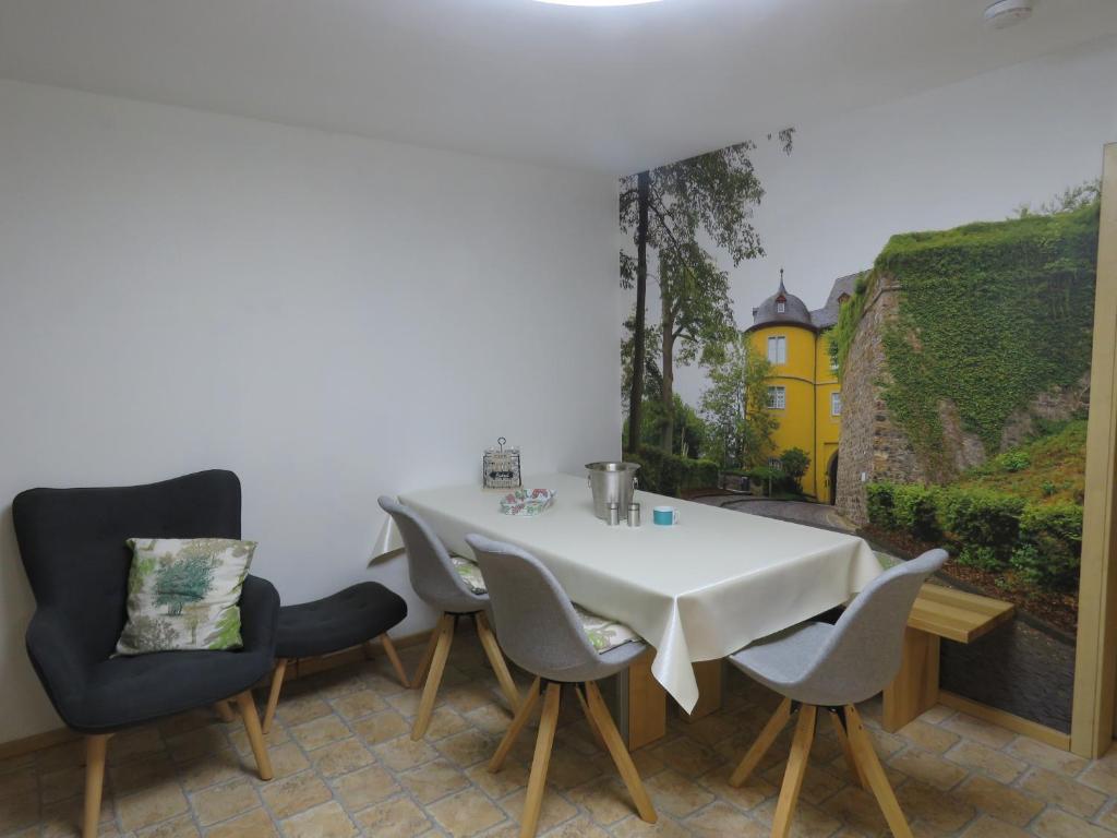 una sala da pranzo con tavolo e sedie bianchi di Haus Waldzauber a Neuhäusel
