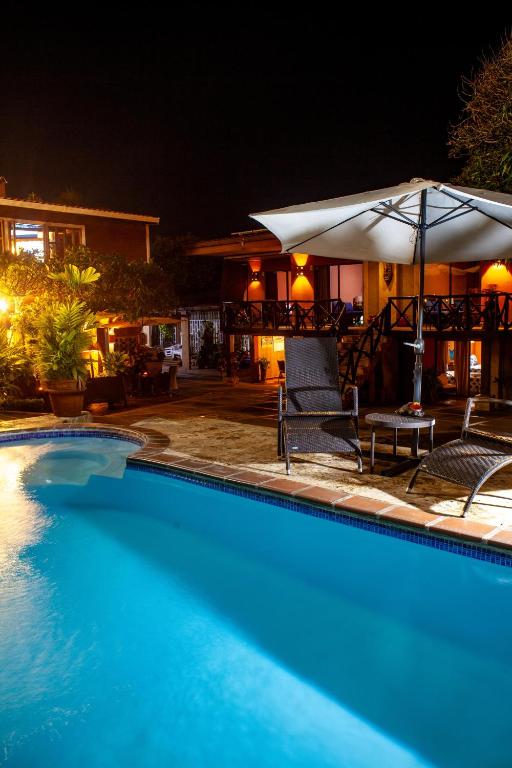 una piscina frente a una casa por la noche en Hotel Mar y Mar, en Puntarenas