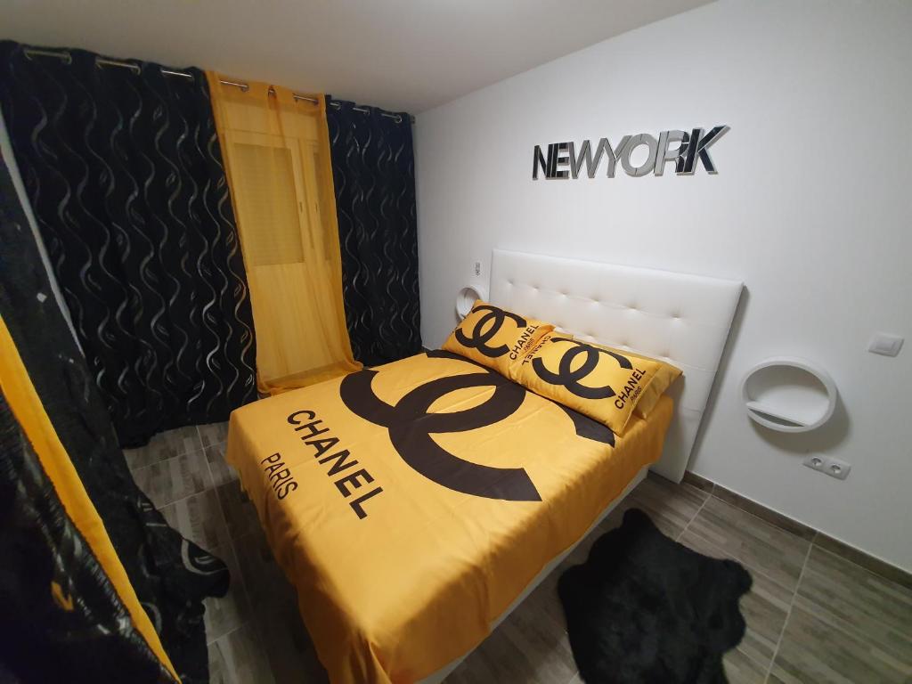 - une petite chambre avec un lit et une couverture jaune dans l'établissement Apartamentos New York, à Vecindario