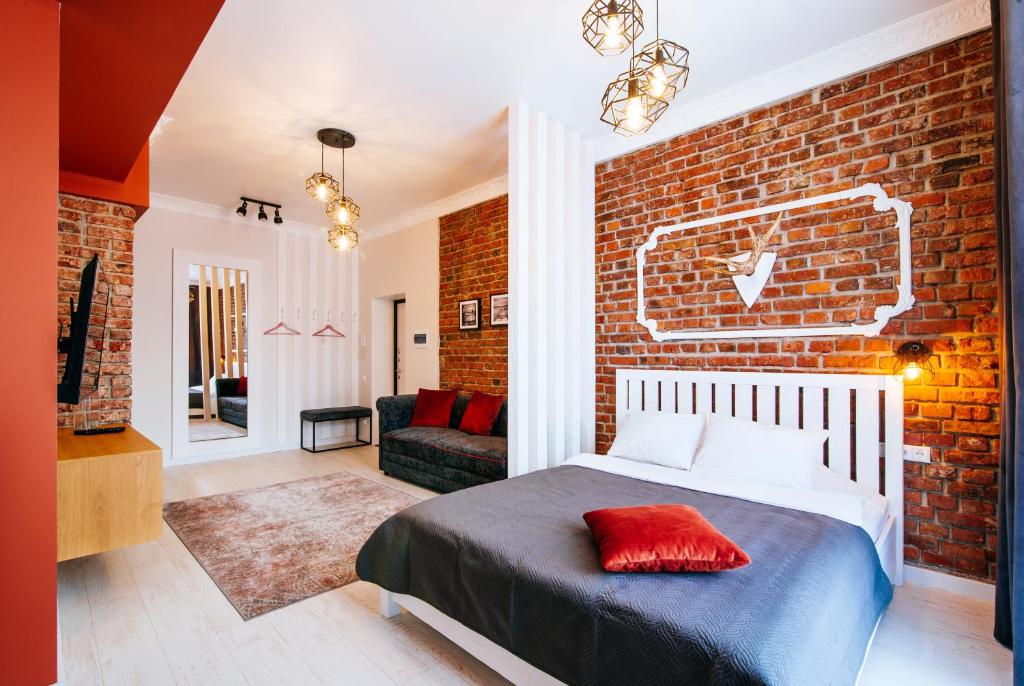 a bedroom with a brick wall and a bed at 10 Apartment on ploshad Pobedi in Minsk