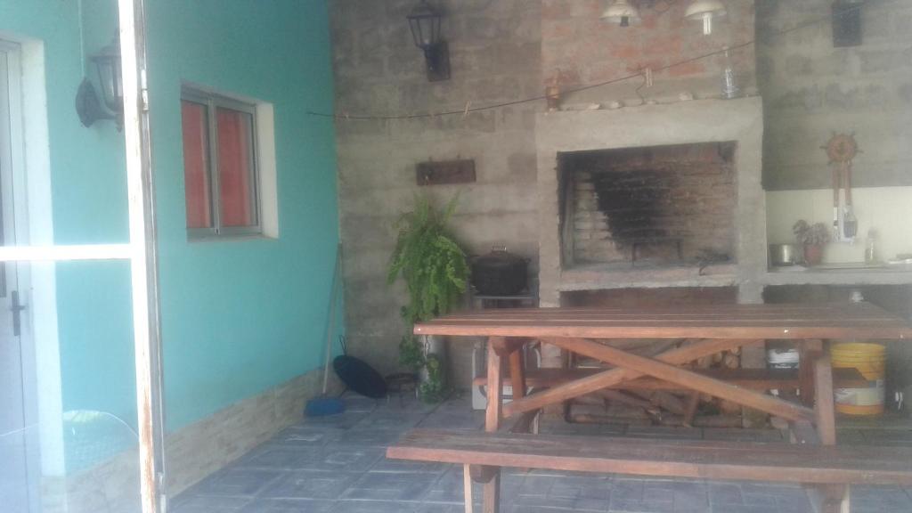 a wooden table in a room with a fireplace at Monoambientes Sandú in Durazno