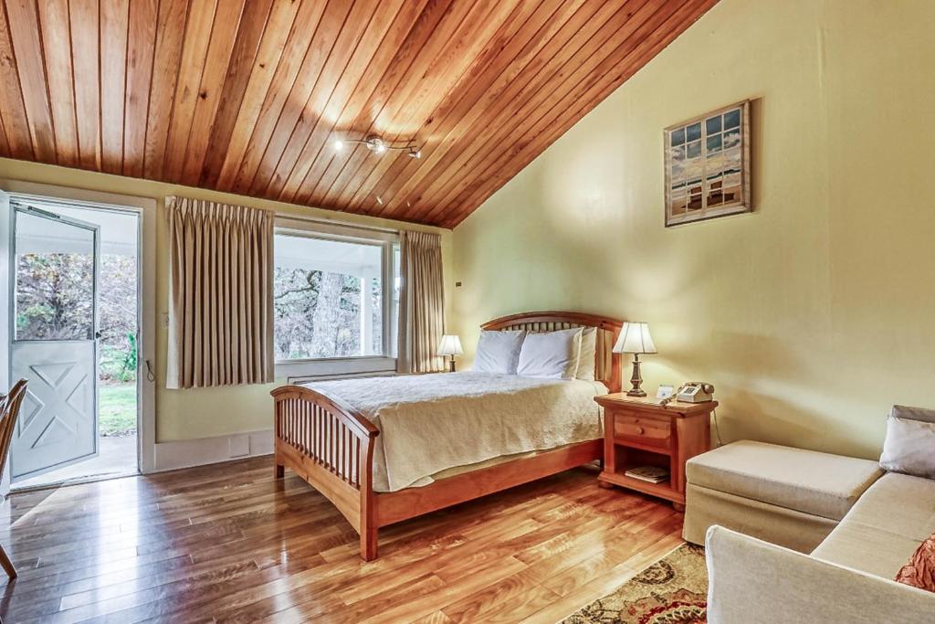 Island Inn في أوك بلوفس: غرفة نوم بسرير وسقف خشبي