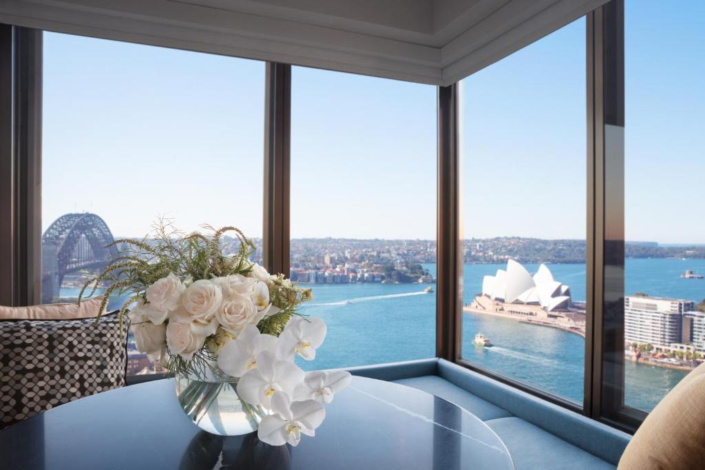 
a vase of flowers sitting on a balcony overlooking a city at Four Seasons Hotel Sydney in Sydney
