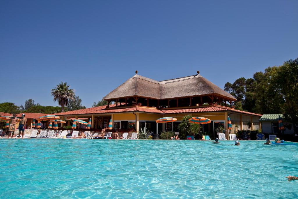 un complejo con piscina con gente en el agua en Camping Free Beach, en Marina di Bibbona