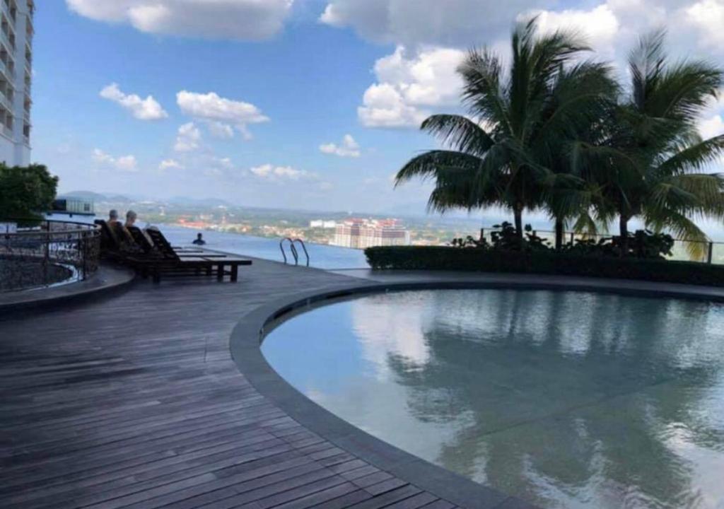 uma piscina num deque com vista para a água em Silverscape Seaview B25-13 em Malaca