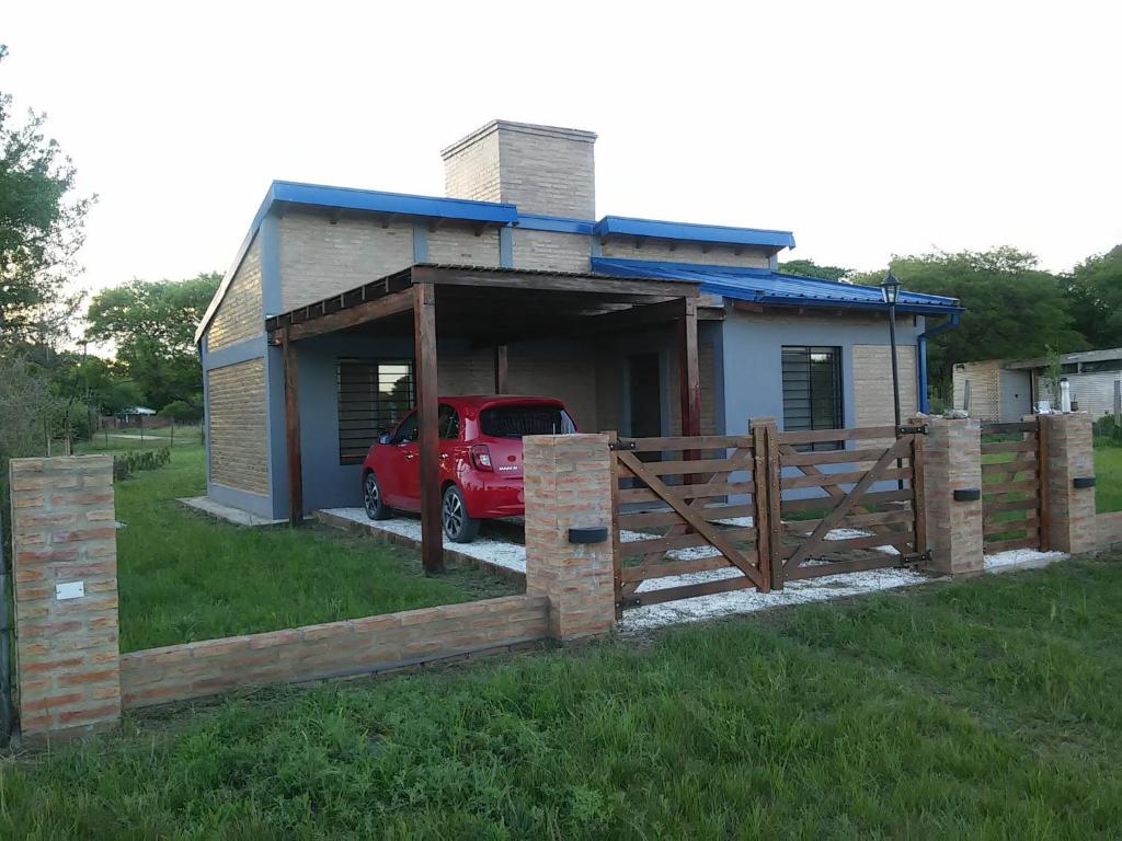una pequeña casa con un coche rojo en un garaje en Cabaña Azul en 