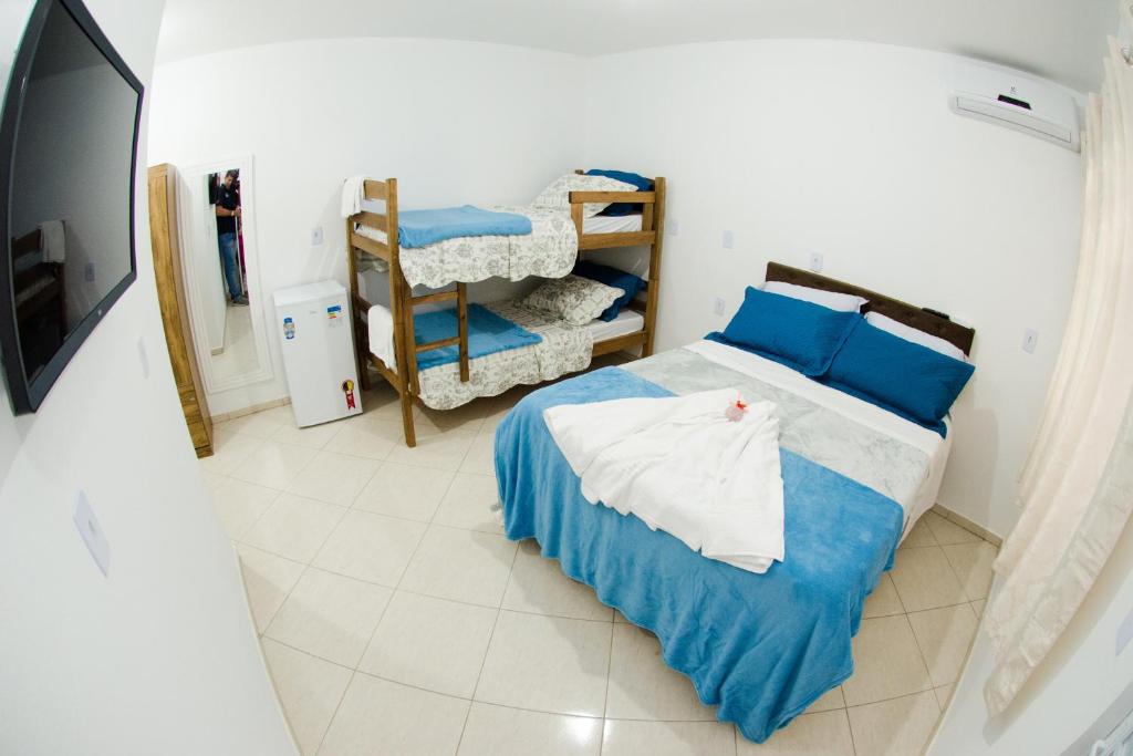 a bedroom with a bed with blue and white sheets at PÉROLA SUÍTES - PENHA in Penha