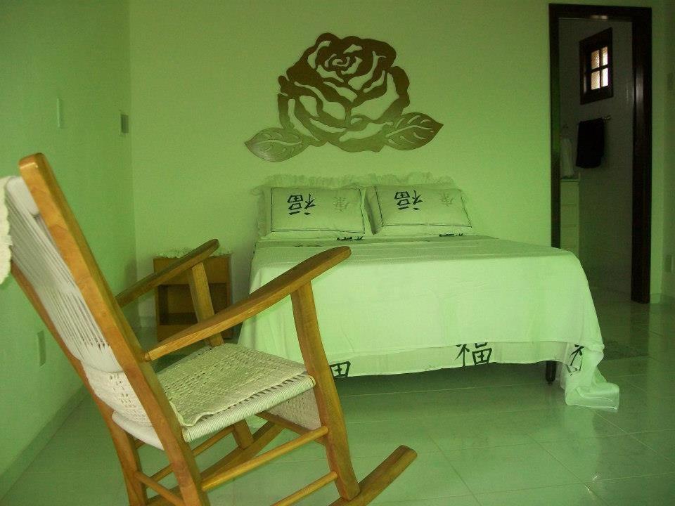 a bedroom with a bed and a rocking chair at Recanto Solar da Paz in Ilha de Boipeba