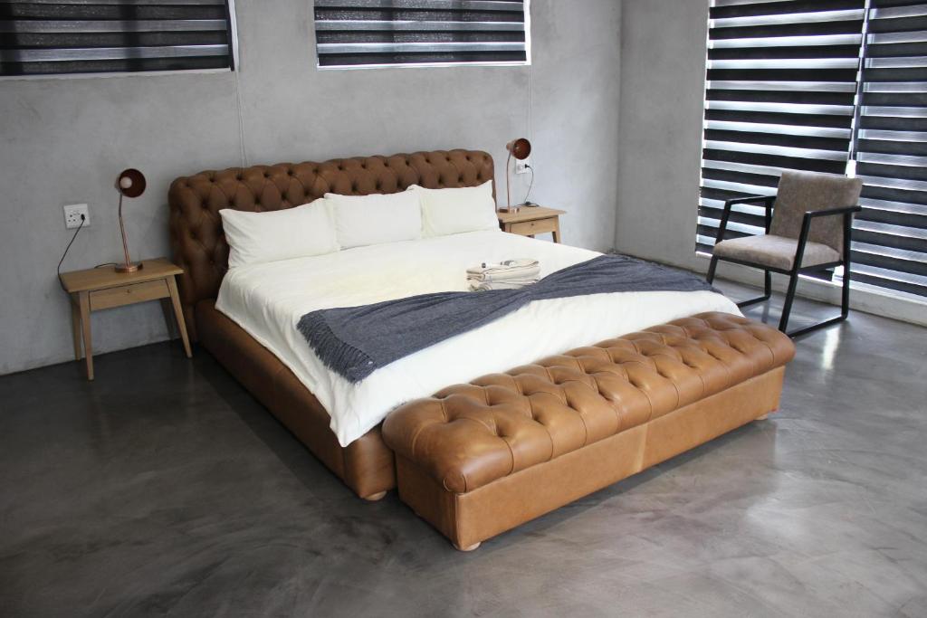 托霍延杜的住宿－ANISA GUESTHOUSE，一间卧室配有一张大床和真皮沙发