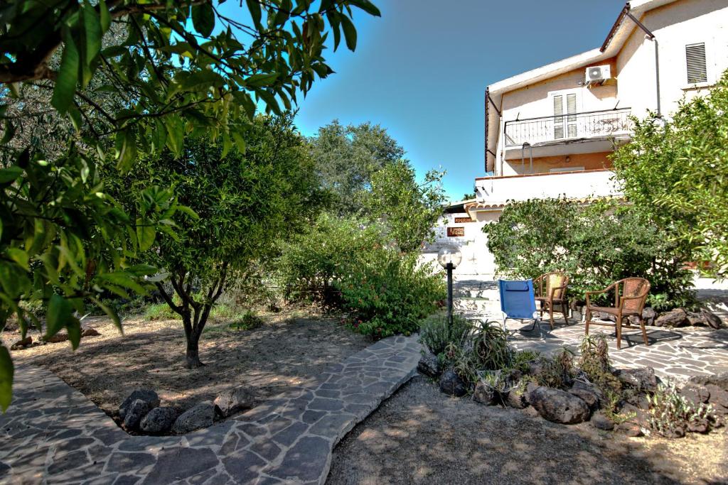 un jardín frente a un edificio con árboles en Villa Arancio, en Cala Liberotto