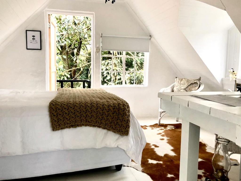 a white bedroom with a bed and a window at Drewry Lane in Howick