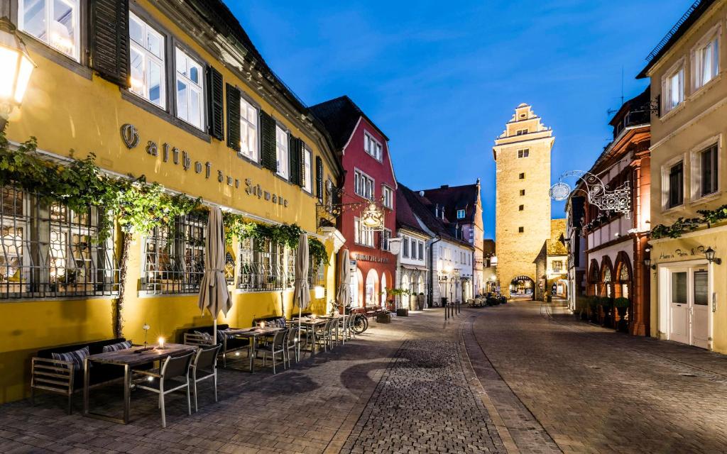 Romantik Hotel Zur Schwane في فولكاخ: شارع فاضي فيه طاولات وكراسي في مدينه