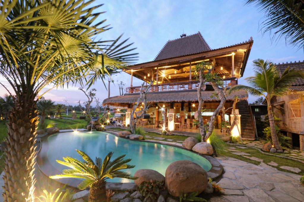 a resort with a swimming pool in front of a building at Pondok Sebatu Eco Lodge in Tegalalang