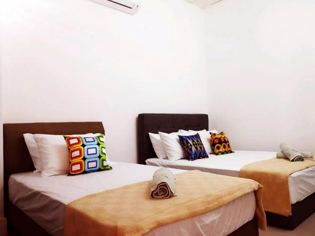 two beds in a room with white walls at 3133 Heritage Home in George Town