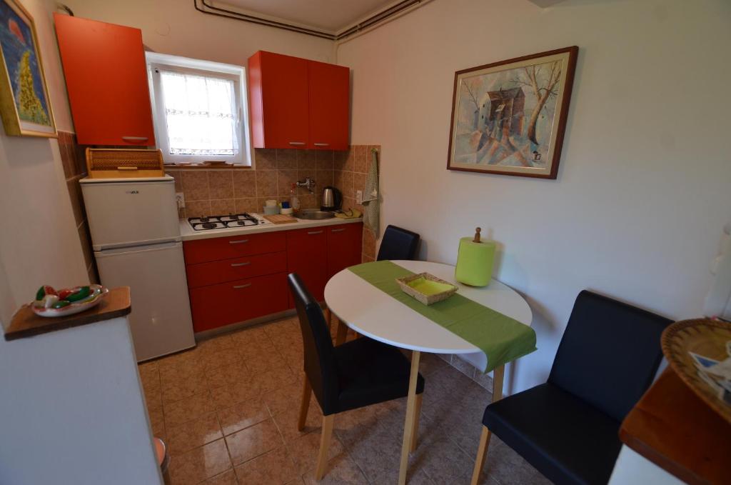 a kitchen with red cabinets and a table with chairs at Cozy apartment Ernesto*good location*Rovinj in Rovinj