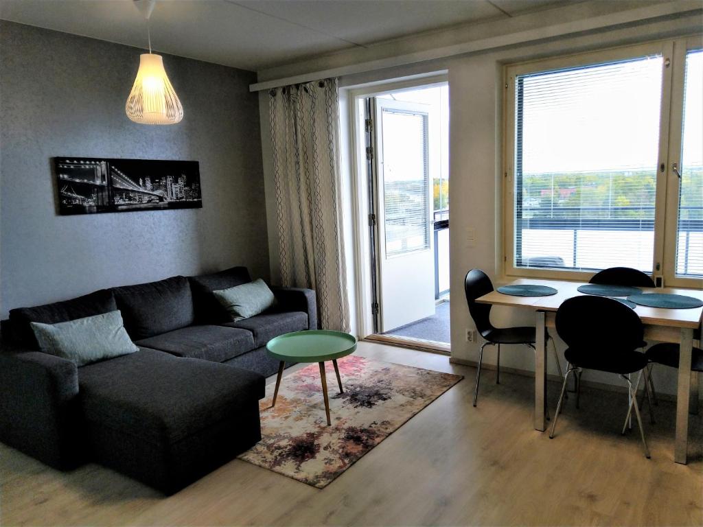 a living room with a couch and a table at Pro Apartments 2 in Vaasa