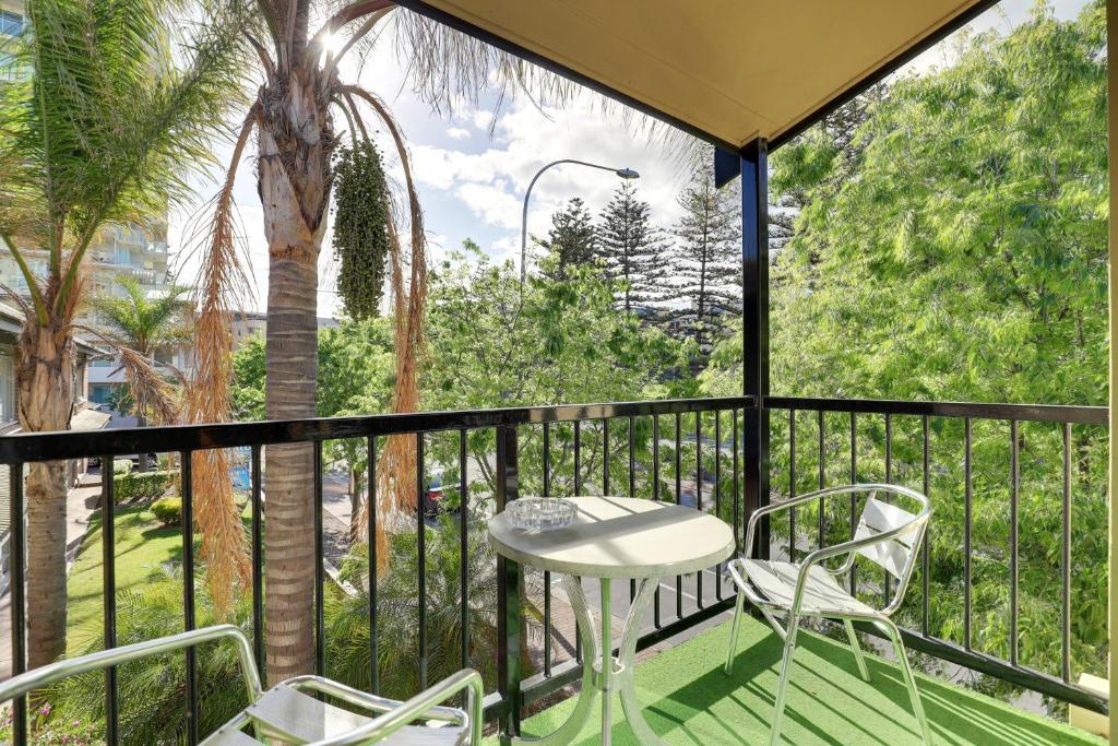 a patio area with a pool and a balcony at Bayview Apartments in Adelaide