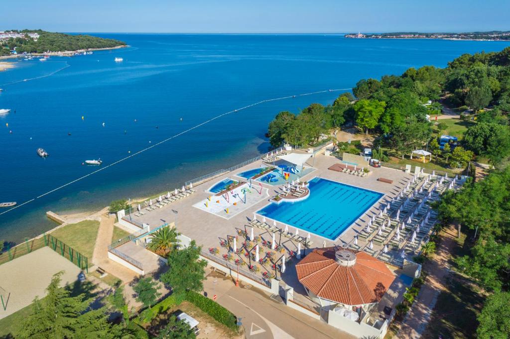 an aerial view of a resort with a pool and the water at Mobilhome Victoria Camping Lanterna in Poreč