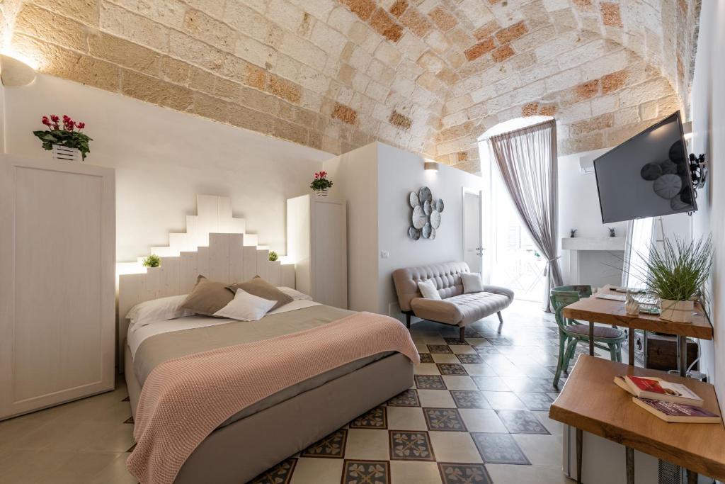 una camera con un grande letto e un soggiorno di D'aprile Dimore a Polignano a Mare