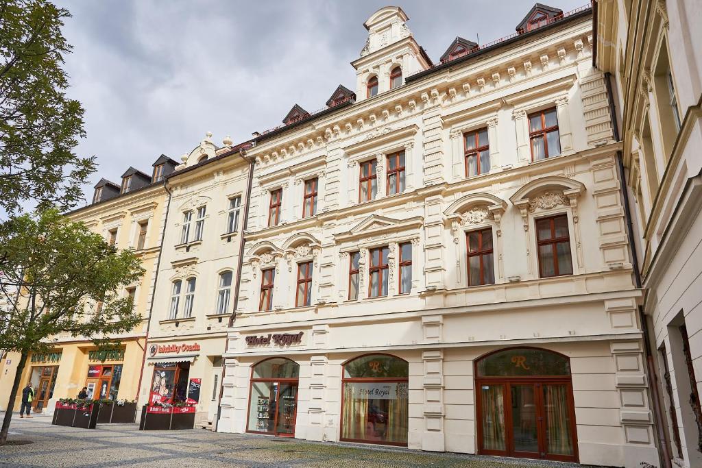 un gran edificio blanco con una torre de reloj en la parte superior en Hotel Royal, en Chomutov