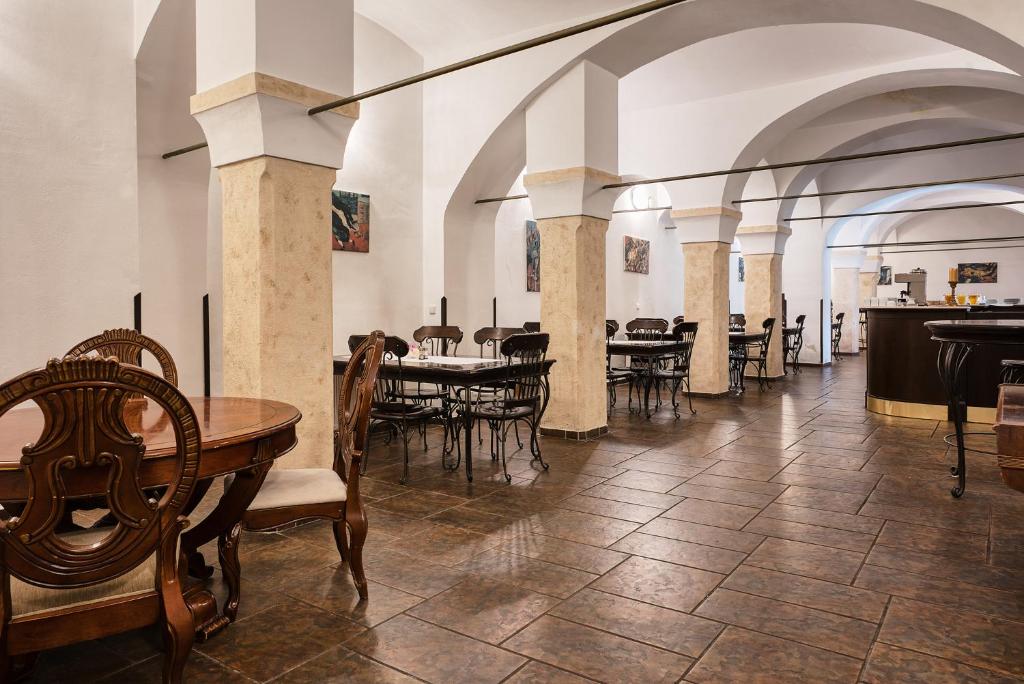 un comedor con mesas y sillas en un edificio en Hotel Royal, en Chomutov