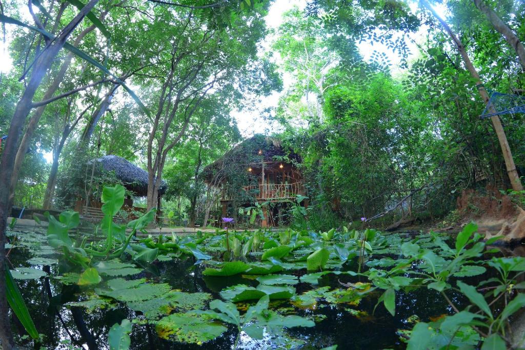 a statue of an elephant in the middle of a forest at Mutu Village treehouse tourist board approved bungalow in Habarana