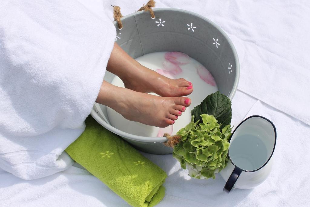 a woman is washing her feet in a bucket with lettuce at Hotel am Schloß Apolda in Apolda