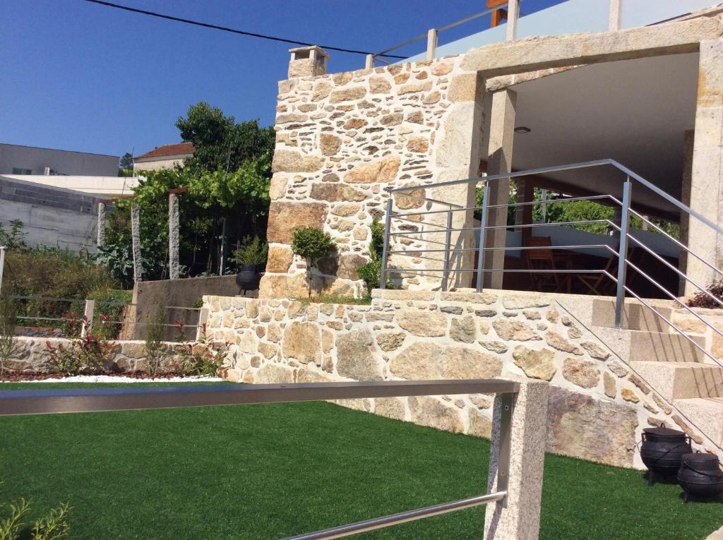 a stone building with a yard with green grass at Casa do Caminho - Ossela in Oliveira de Azemeis