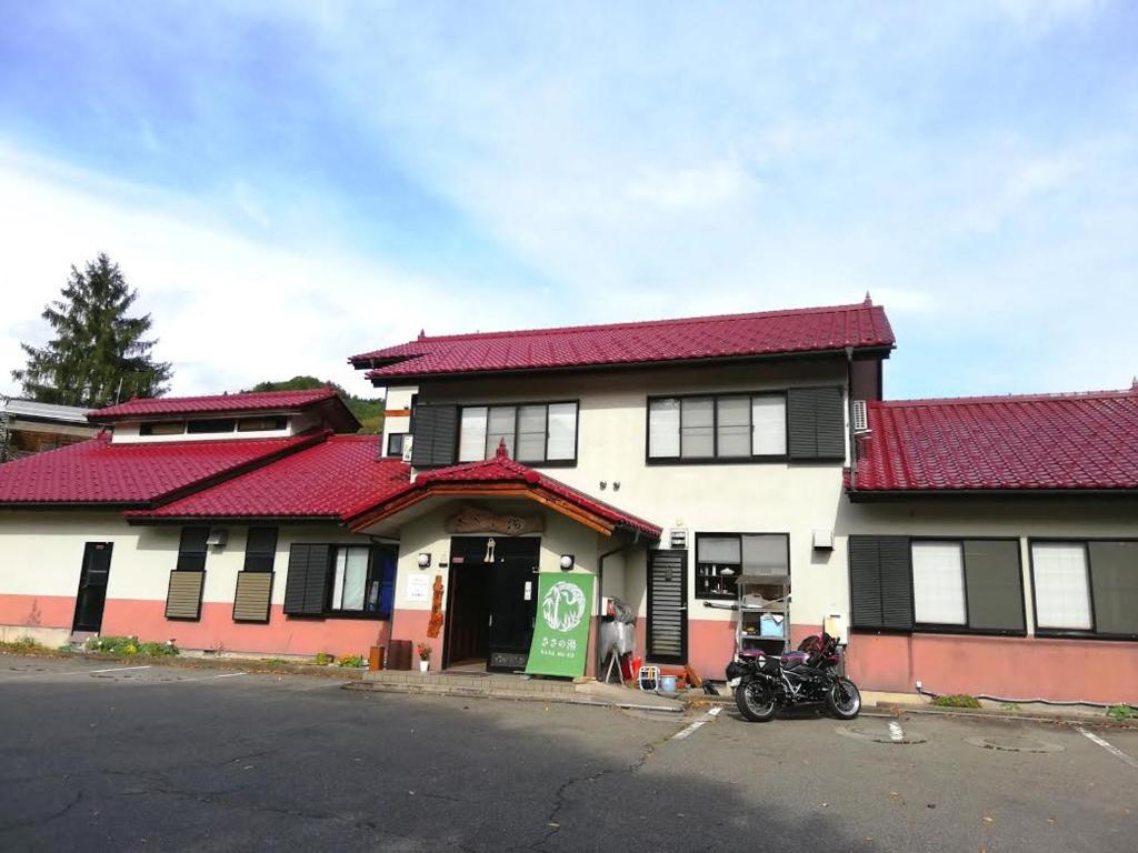 un edificio con una moto parcheggiata di fronte di 幡谷温泉 ささの湯 a Hataya
