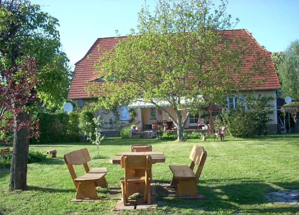 a picnic table and benches in front of a house at Ferienwohnung Marienkäfer in Wulkow