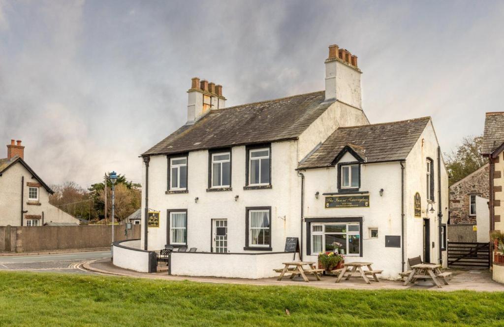 雷文格拉斯的住宿－The Inn at Ravenglass，前面设有野餐桌的白色建筑