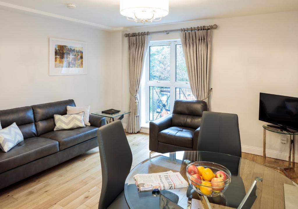 a living room with a couch and a glass table at Baggotrath House Apartments, Newbridge Ave, Dublin 4 in Dublin