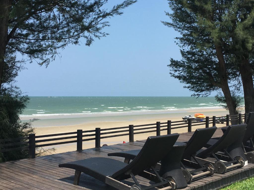 a wooden deck with chairs and a beach at Las Tortugas Apartment Unit C101 in Khao Tao