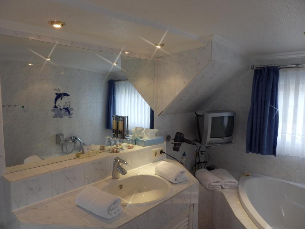 y baño con lavabo, bañera y espejo. en Hotelschiff Perle Bremen, en Bremen