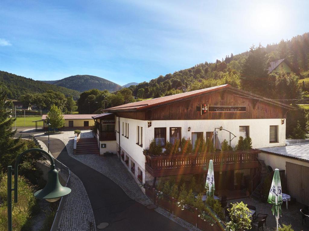 a large building with a balcony and a house at Gasthaus&Pension "Grünes Herz" in Unterschönau