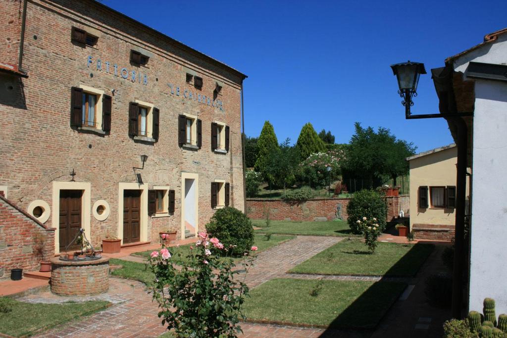コルトーナにあるFattoria Le Chianacceのレンガ造りの古い建物で、その前に庭園がある