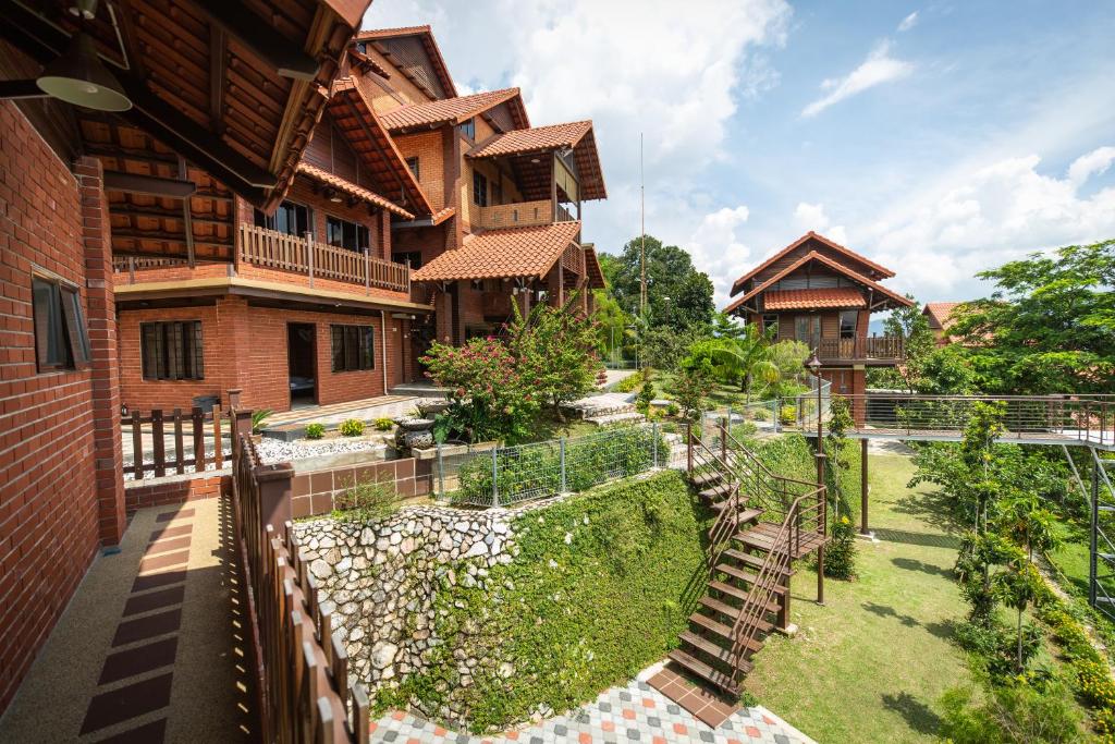a courtyard of a house with a fence at Red House the Garden Stay in Bukit Tinggi by PLAY in Bentong
