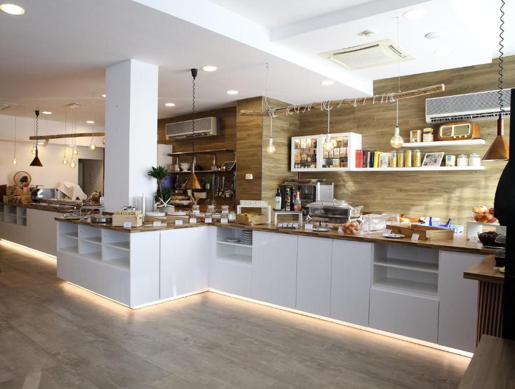 a kitchen with white cabinets and a counter top at Hotel Villa del Parco in Rimini