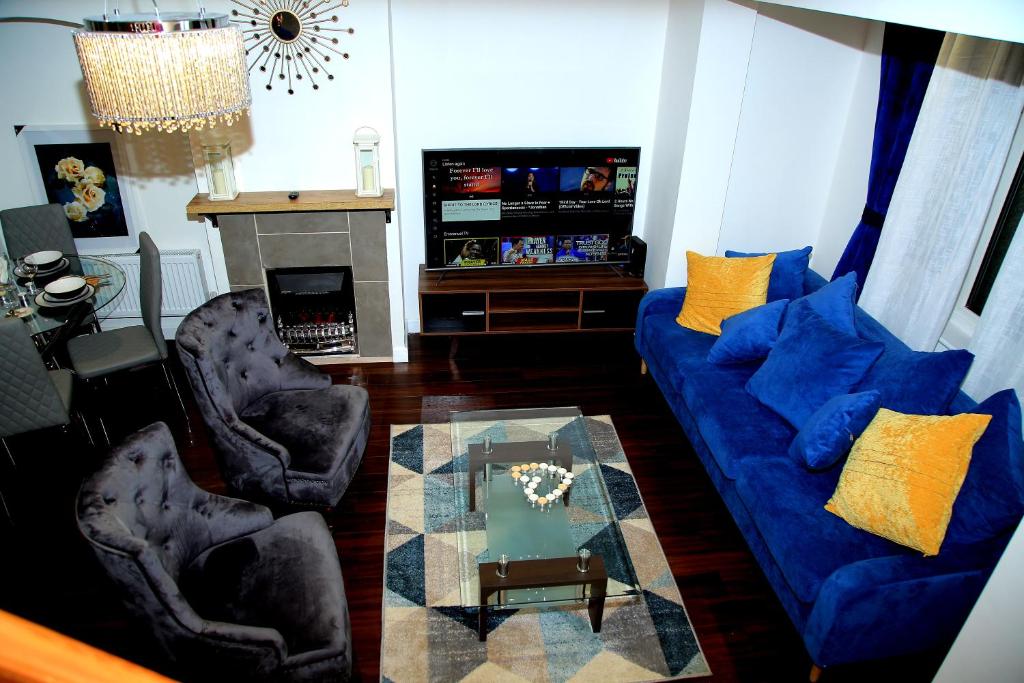 a living room with a blue couch and two chairs at A Modern, Comfy Newly Remodeled 2bd House in Barking