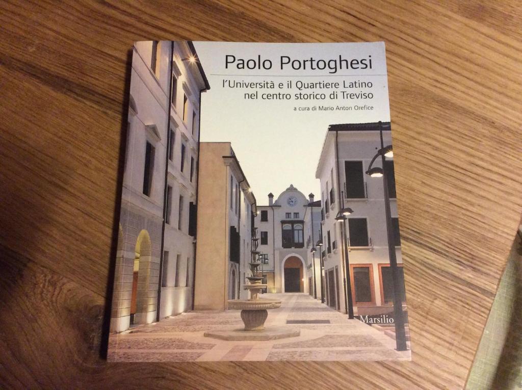 a book on a table with a picture of a street at Suite Latina - San Leonardo in Treviso