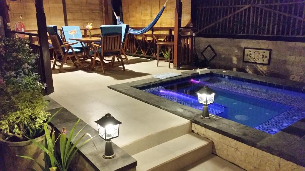 una piscina con due luci e un tavolo di Dennis Holiday Bungalow a Jasri