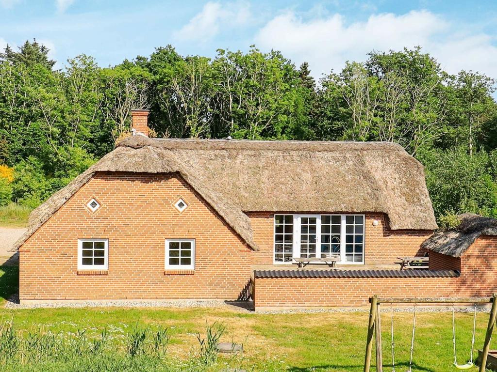 an old brick house with a thatched roof at 14 person holiday home in Ulfborg in Husby
