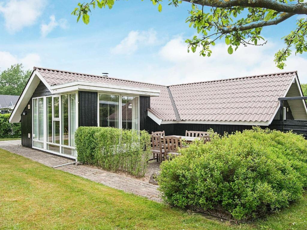 una casa negra con una mesa de picnic en un patio en 4 person holiday home in Esbjerg V, en Hjerting
