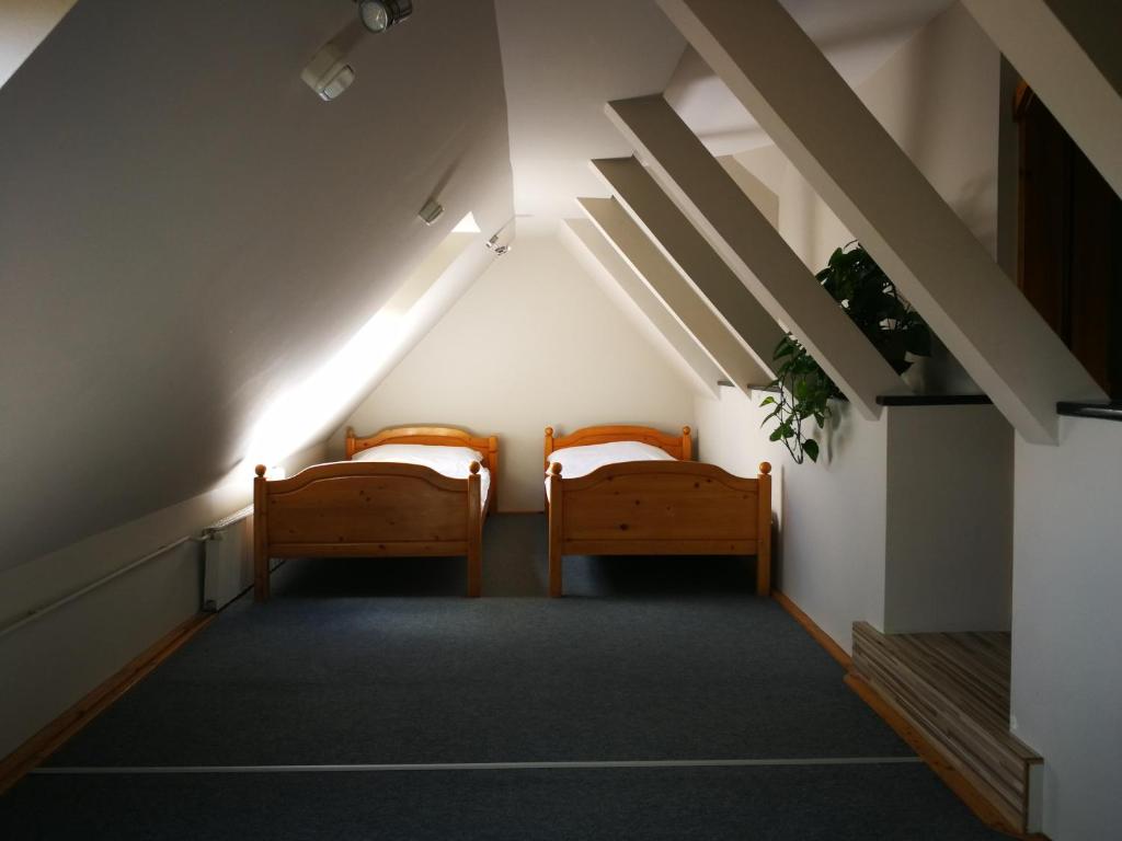 a hallway with two beds in a building at Tornyos Panzió és Étterem in Matrafured