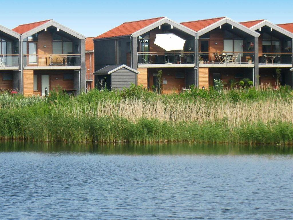 una fila de casas junto a un cuerpo de agua en 6 person holiday home in Bogense, en Bogense