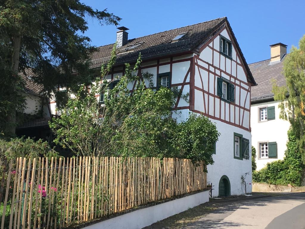 a white and black house with a wooden fence at Zum-Goldenen-Schaf in Blankenheim