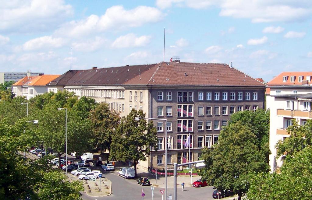 um grande edifício com estacionamento numa cidade em Hostel VITA Berlin em Berlim