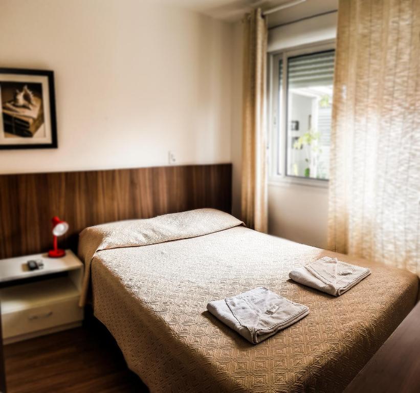 ein Schlafzimmer mit einem Bett mit zwei Handtüchern darauf in der Unterkunft Porto Rei Residence Hotel in Rio Grande